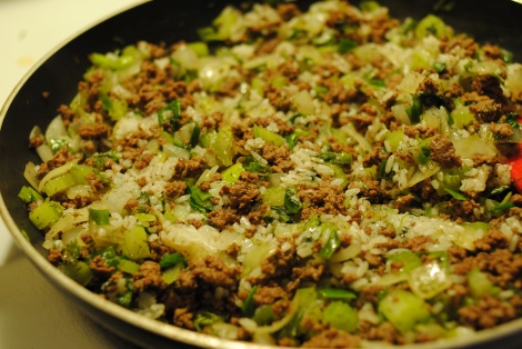 Cooking beef, vegetables, rice, and dill together for stuffed cabbage rolls (photo)